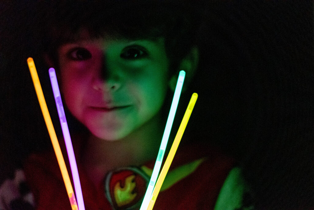 Child in dark with glow sticks